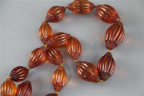 A Chinese amber necklace overall 66in.. sold with a copy of the catalogue